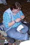 Ehlana working on wire-woven fairy wings during the post-con party. (FC2002)